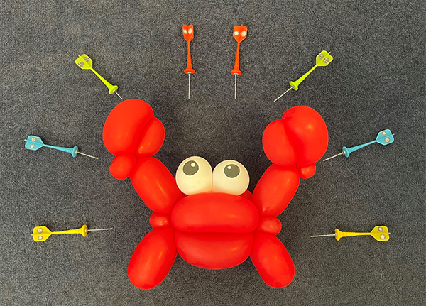 A red balloon crab, surrounded by darts with pictures of vesicles on them pointing at the crab A red balloon crab, surrounded by darts with pictures of vesicles on them pointing at the crab