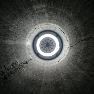 A black and white photo looking into a tunnel with an inspection camera at the end of it A black and white photo looking into a tunnel with an inspection camera at the end of it