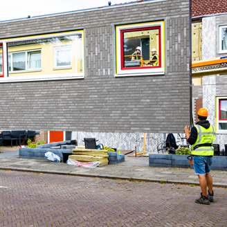 Two workmen controlling the placement of an exterior panel onto the front of a house Two workmen controlling the placement of an exterior panel onto the front of a house