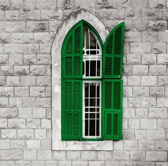 A close-up of a window with green shutters, one open A close-up of a window with green shutters, one open