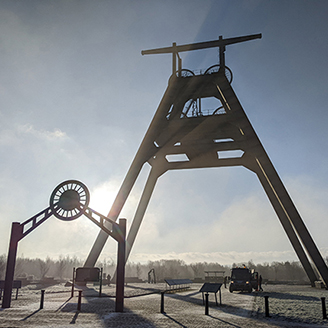 A fixed pulley structure on an old mining site with the sun shining through A fixed pulley structure on an old mining site with the sun shining through