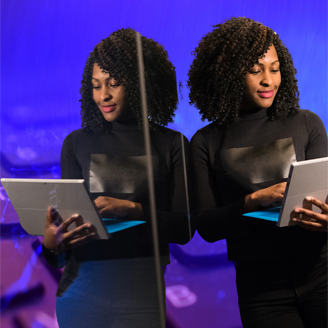 Black woman viewing laptop reflected in mirror Black woman viewing laptop reflected in mirror