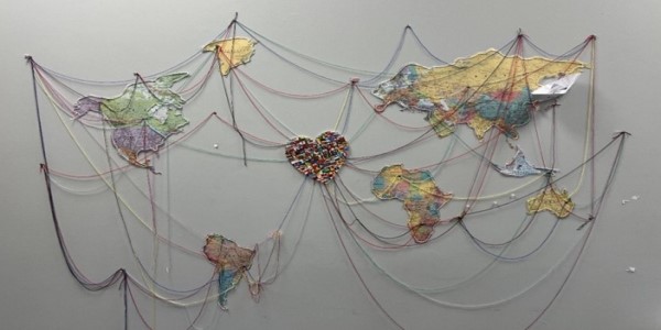 Artwork displaying continents connected by string to a central heart