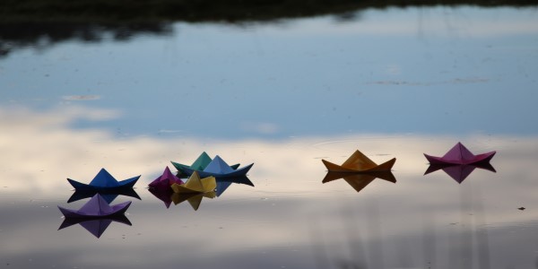Coloured paper boats floating on water Coloured paper boats floating on water