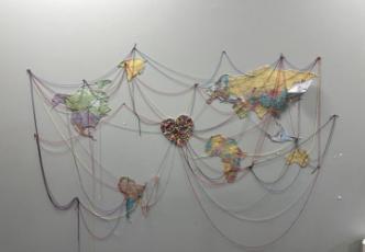 Artwork displaying continents connected by string to a central heart