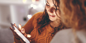 Two people looking at a tablet device