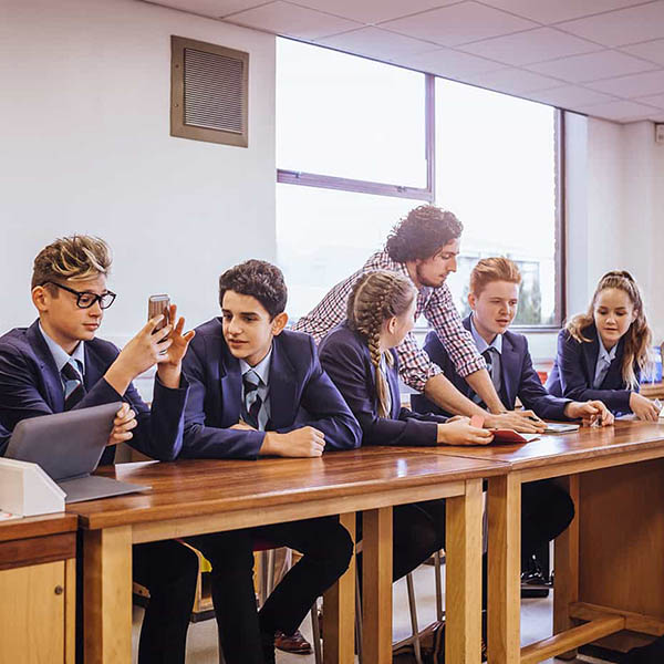 Teenage students with their teacher sat at a table in the science lab. Teenage students with their teacher sat at a table in the science lab.
