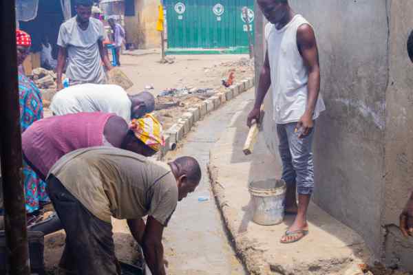 Some men bend down to work on a building site Some men bend down to work on a building site